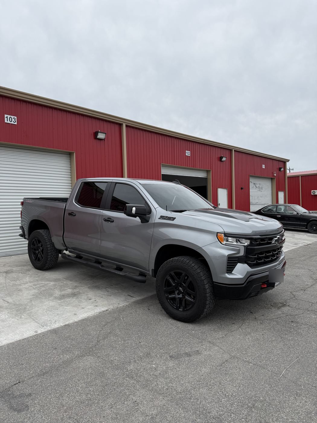 Silver Chevrolet Silverado Trail Boss, side view with tinted windows